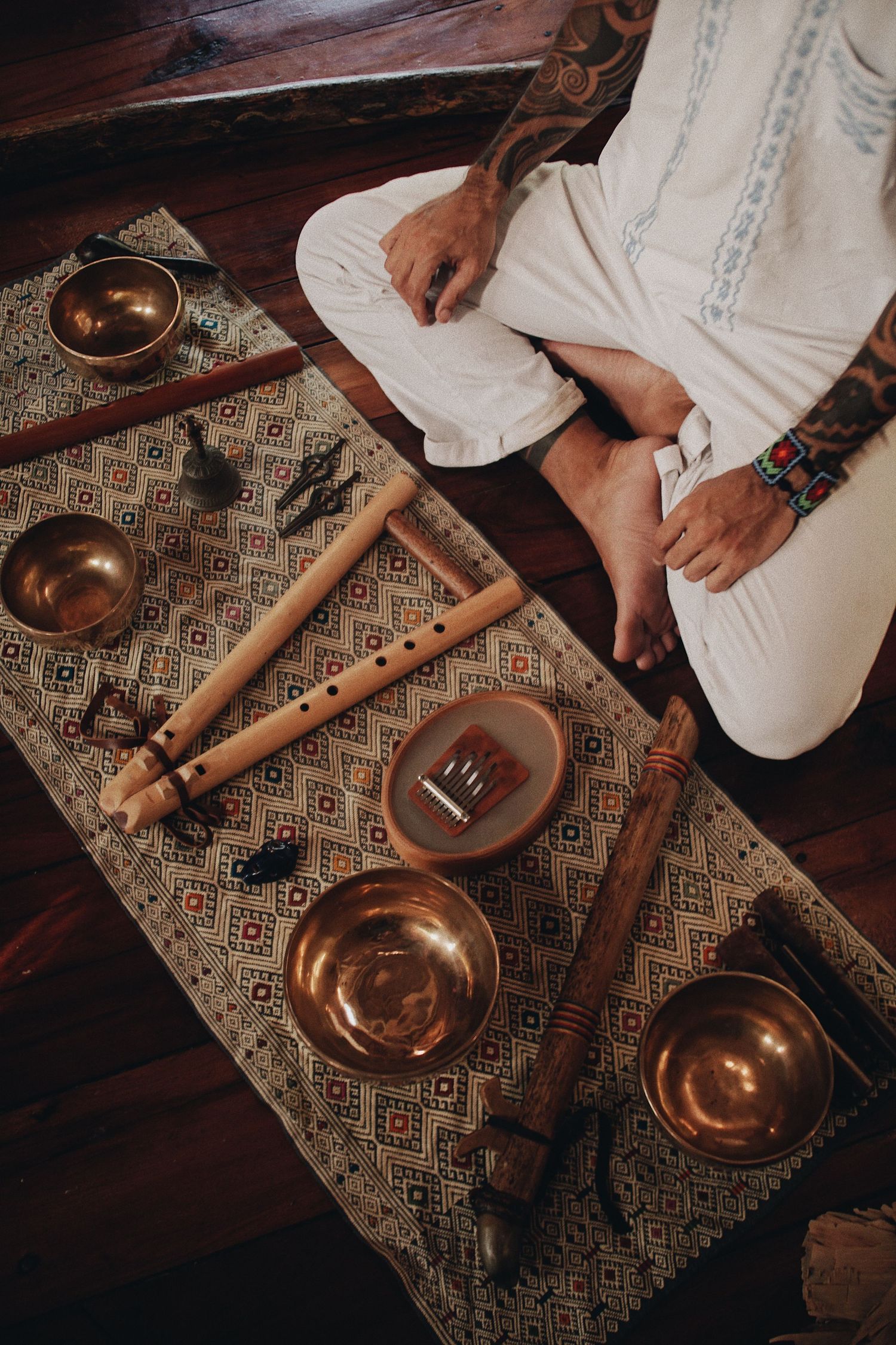 Hands pour traditional Turkish coffee from a copper cezve pot onto a decorative patterned rug in a sequence of images.