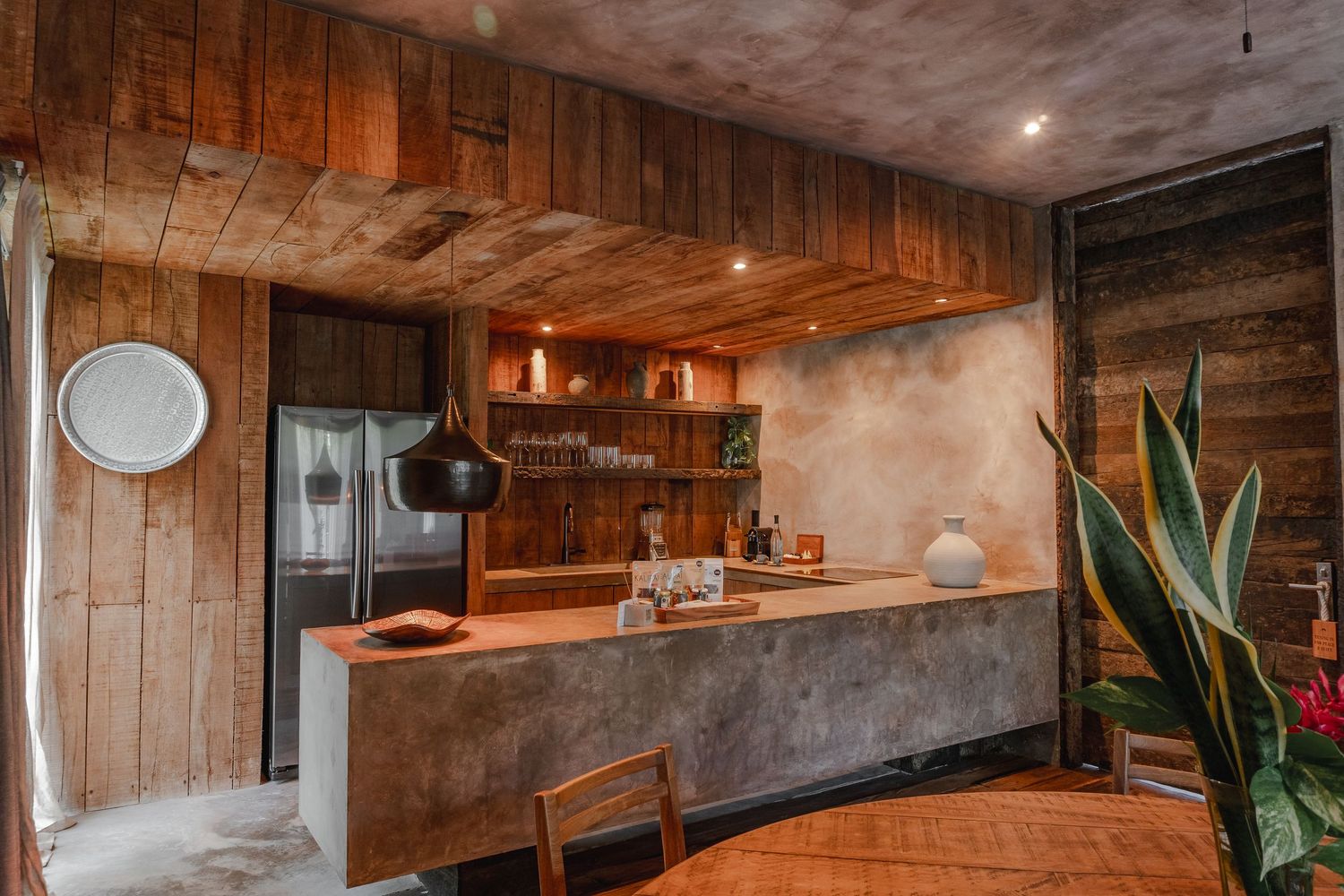 Modern rustic bathroom interior with concrete walls, wooden accents, and warm lighting creates a spa-like atmosphere.