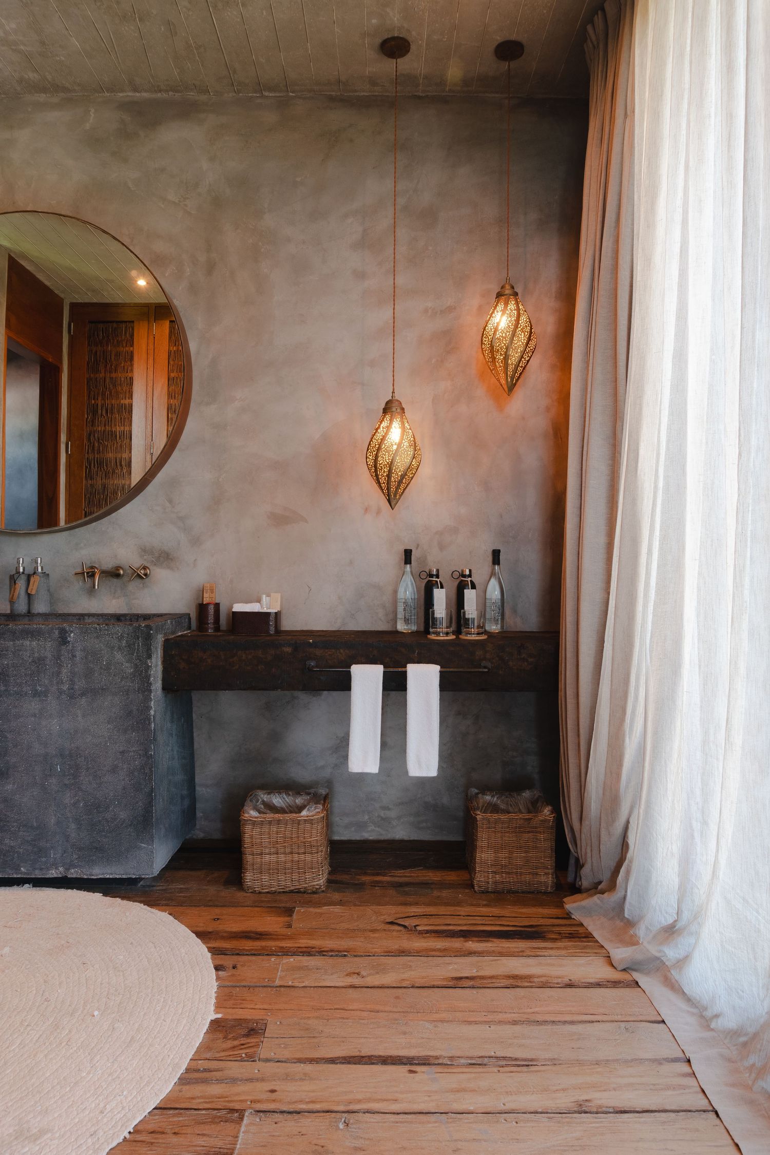 Rustic spa interior with wooden floors, white curtains, and hanging pendant lights.