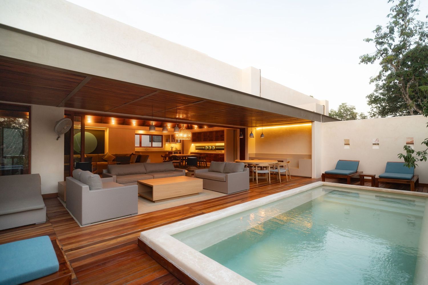 Modern luxury villa with sleek wooden deck and infinity pool overlooking scenic landscape.
