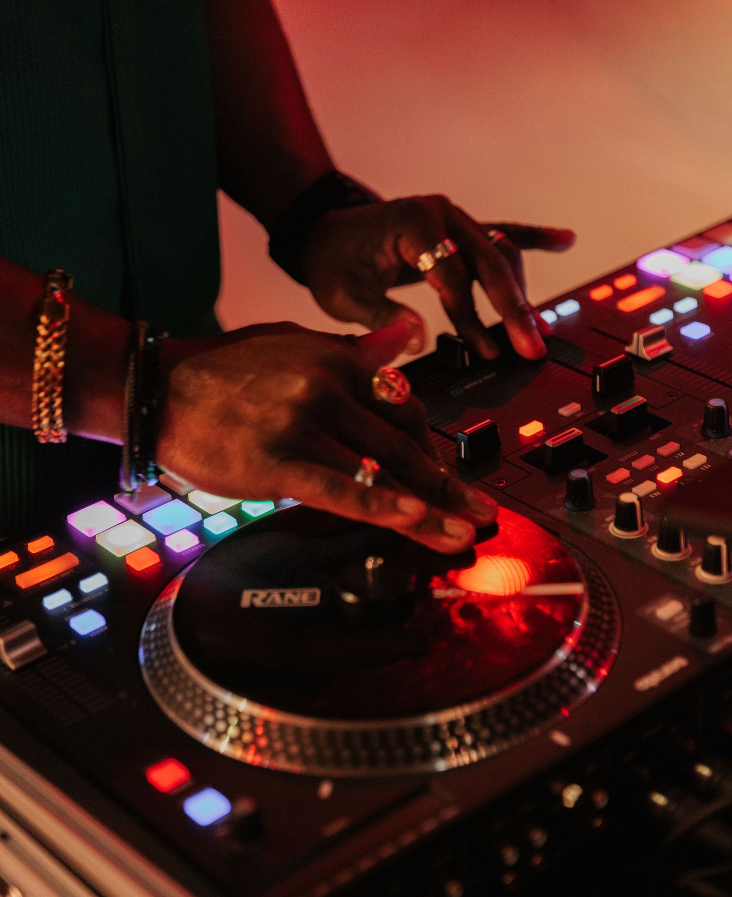 hands operating DJ equipment slightly blured to show action