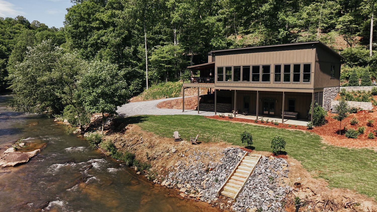 A cabin overlooking the river with stone stairs leading down to the water