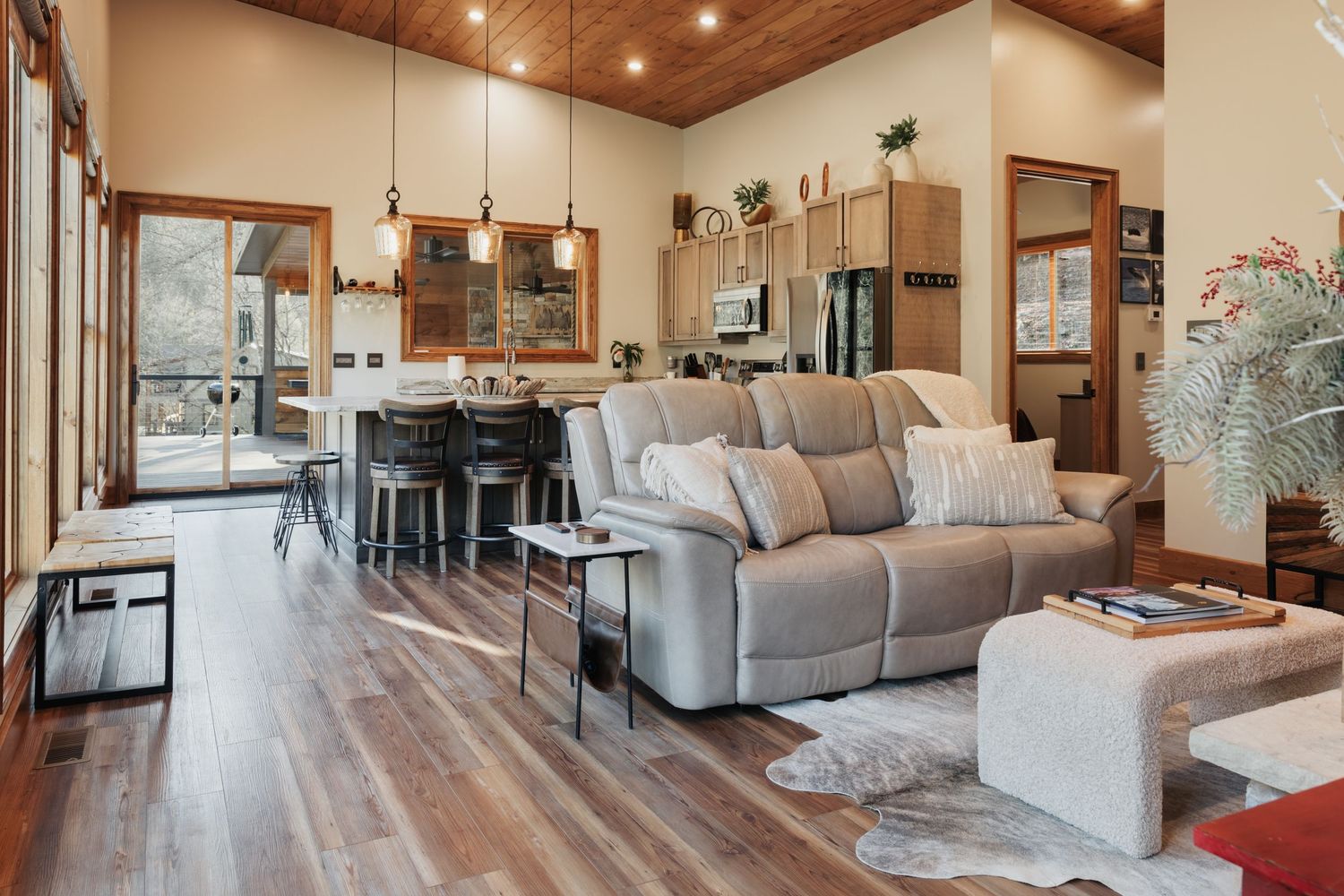 Gray couch with decorative pillows. A glass door going out to the back deck.