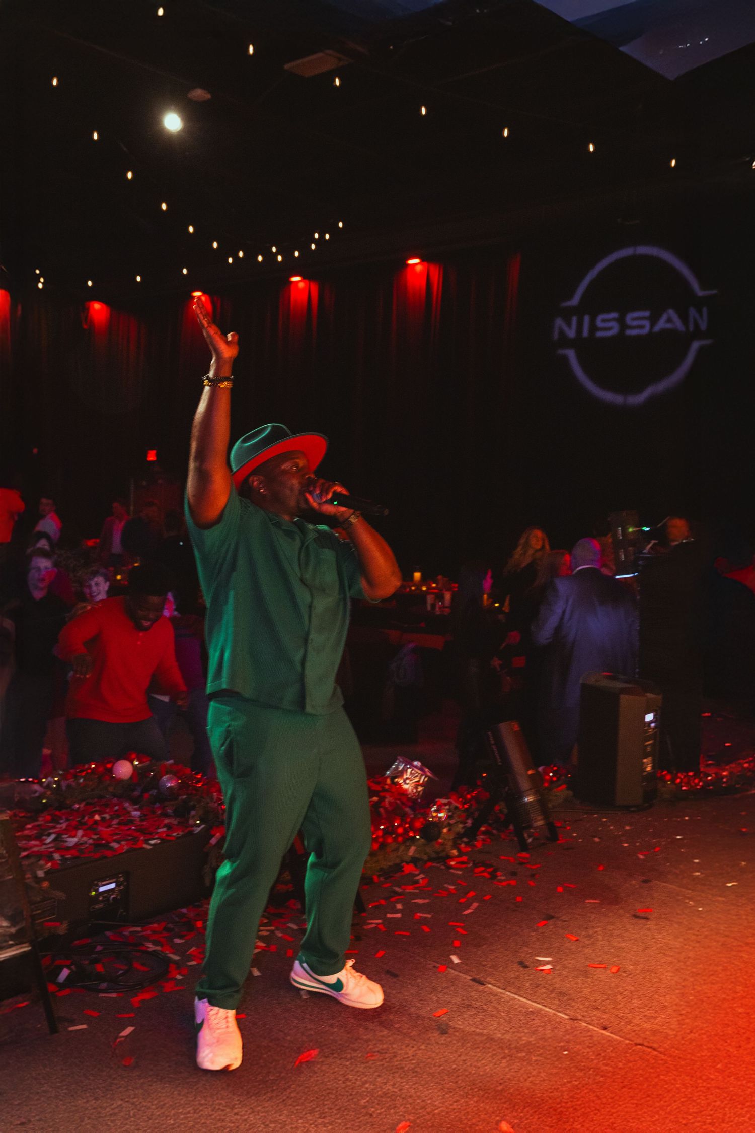 A man stands on the stage, encouraging the audience to celebrate