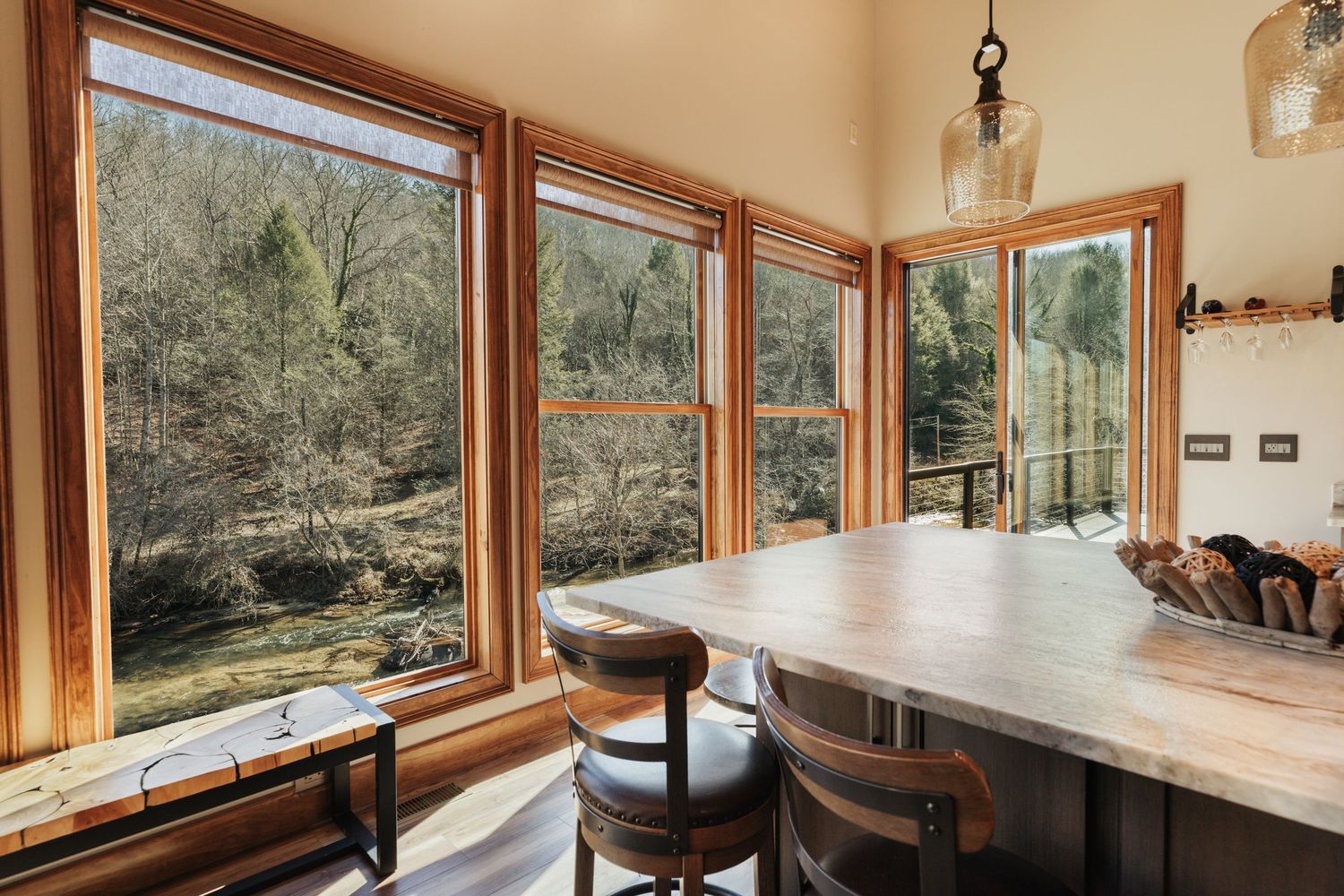 Corner of the kitchen island overlooking large windows and a river down below.