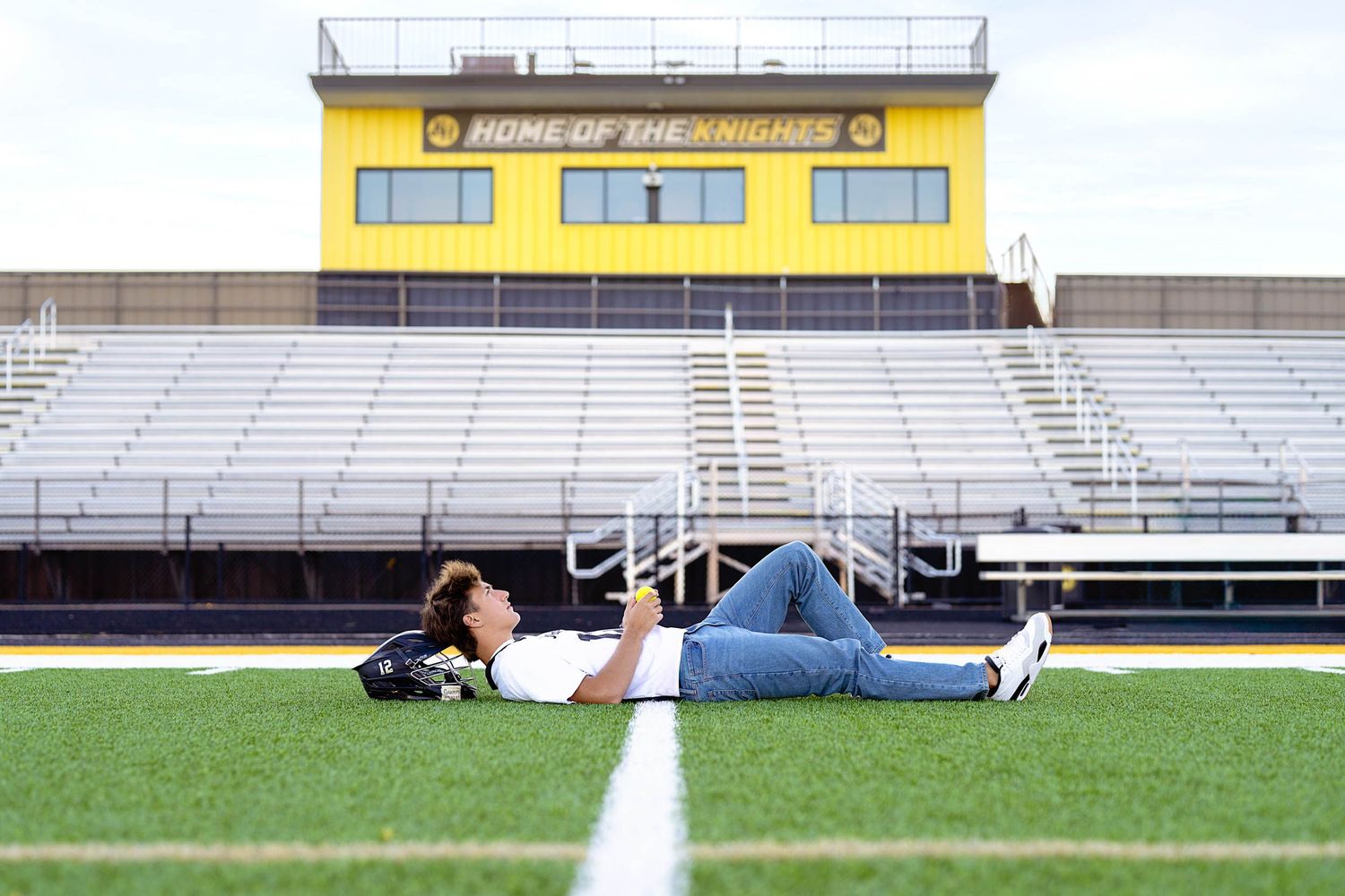 High school lacrosse senior pictures in Grand Rapids featuring a student-athlete on a stadium field.