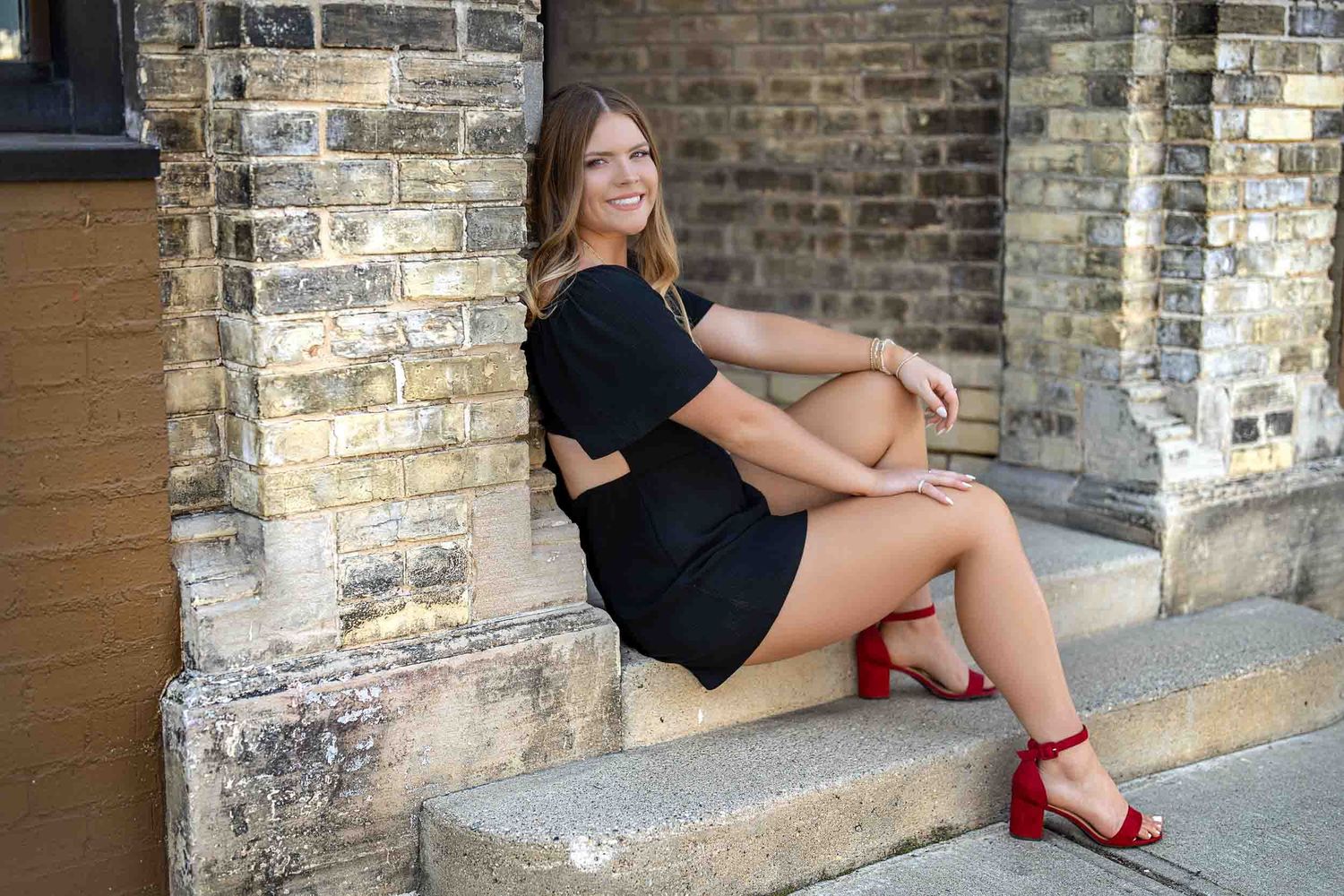 A sequence of photos showing someone sitting on stone steps while wearing red shoes and a black outfit.