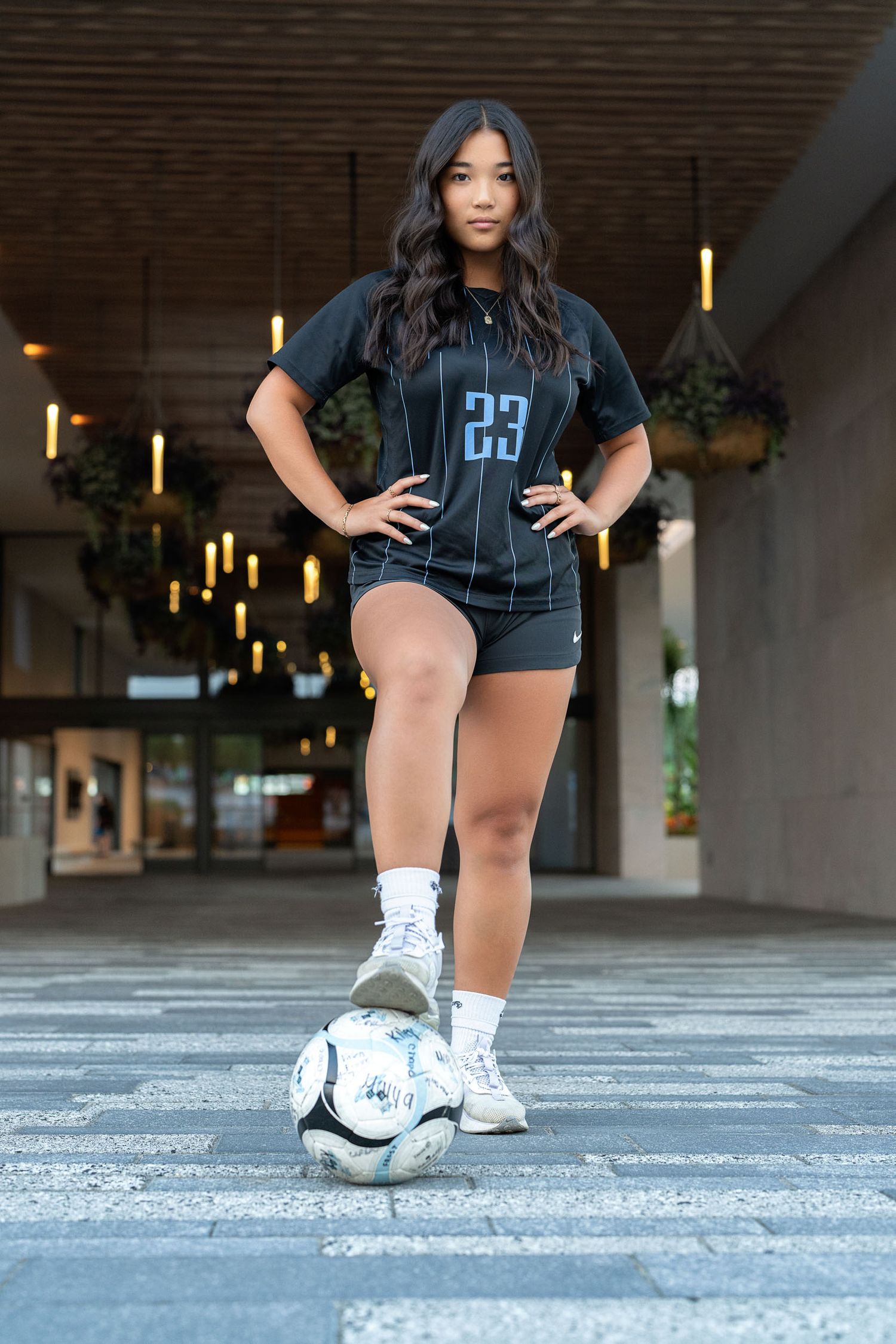 Soccer player showing footwork skills in urban setting with athletic shoes.
