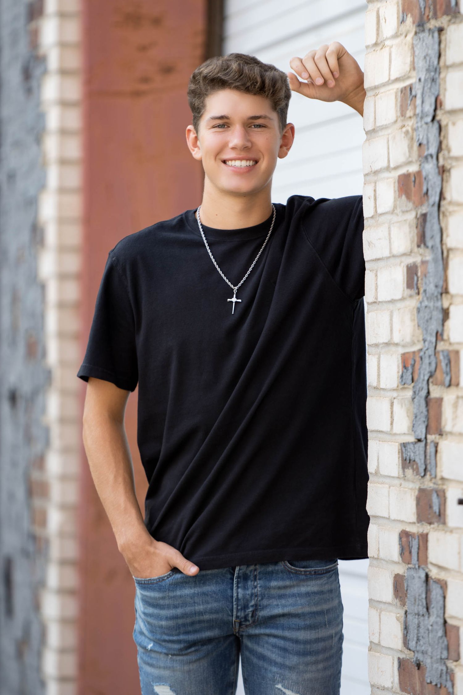 Casual senior guy portrait with a relaxed pose in an urban industrial setting.