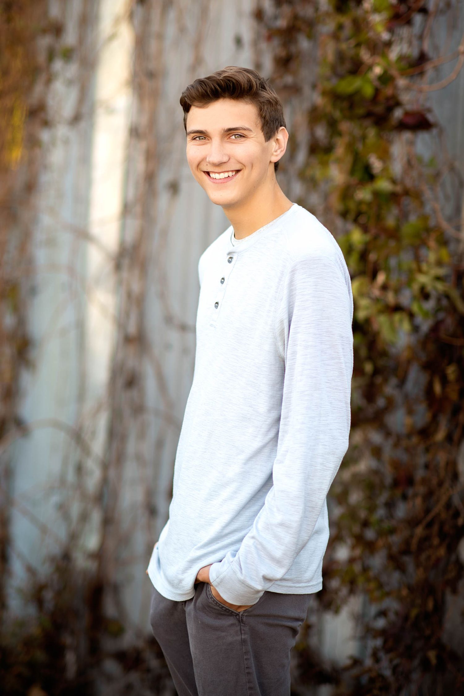 A series of casual outdoor portrait shots against a textured wall with green foliage in natural lighting.