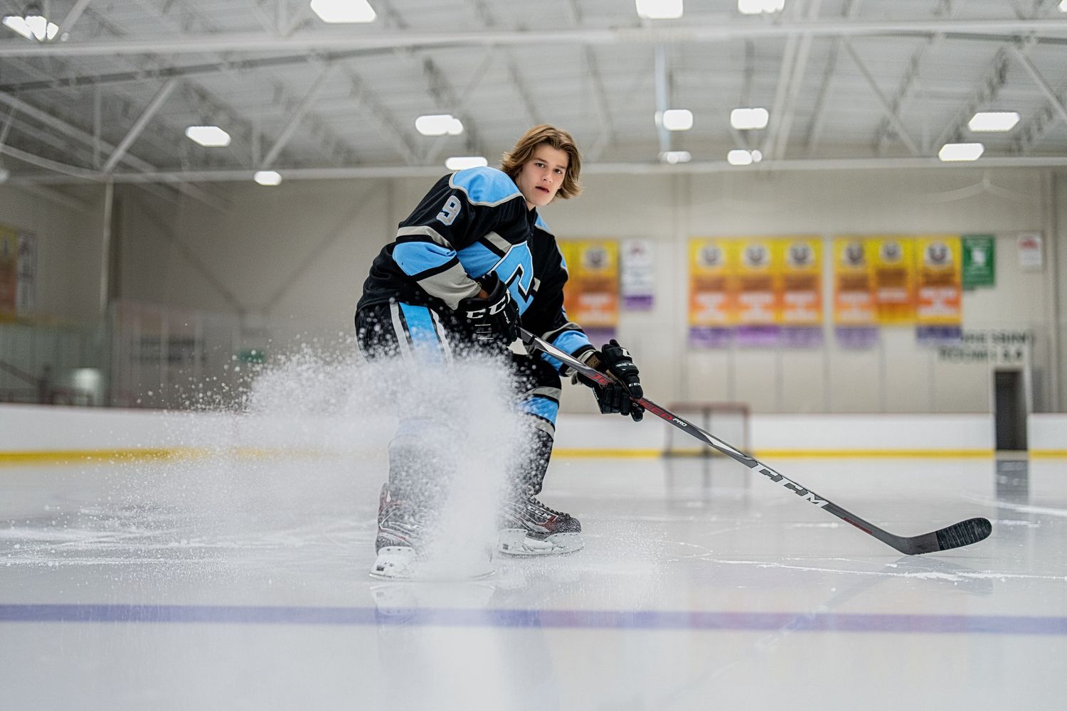 Action shots of hockey players on ice during an indoor game.