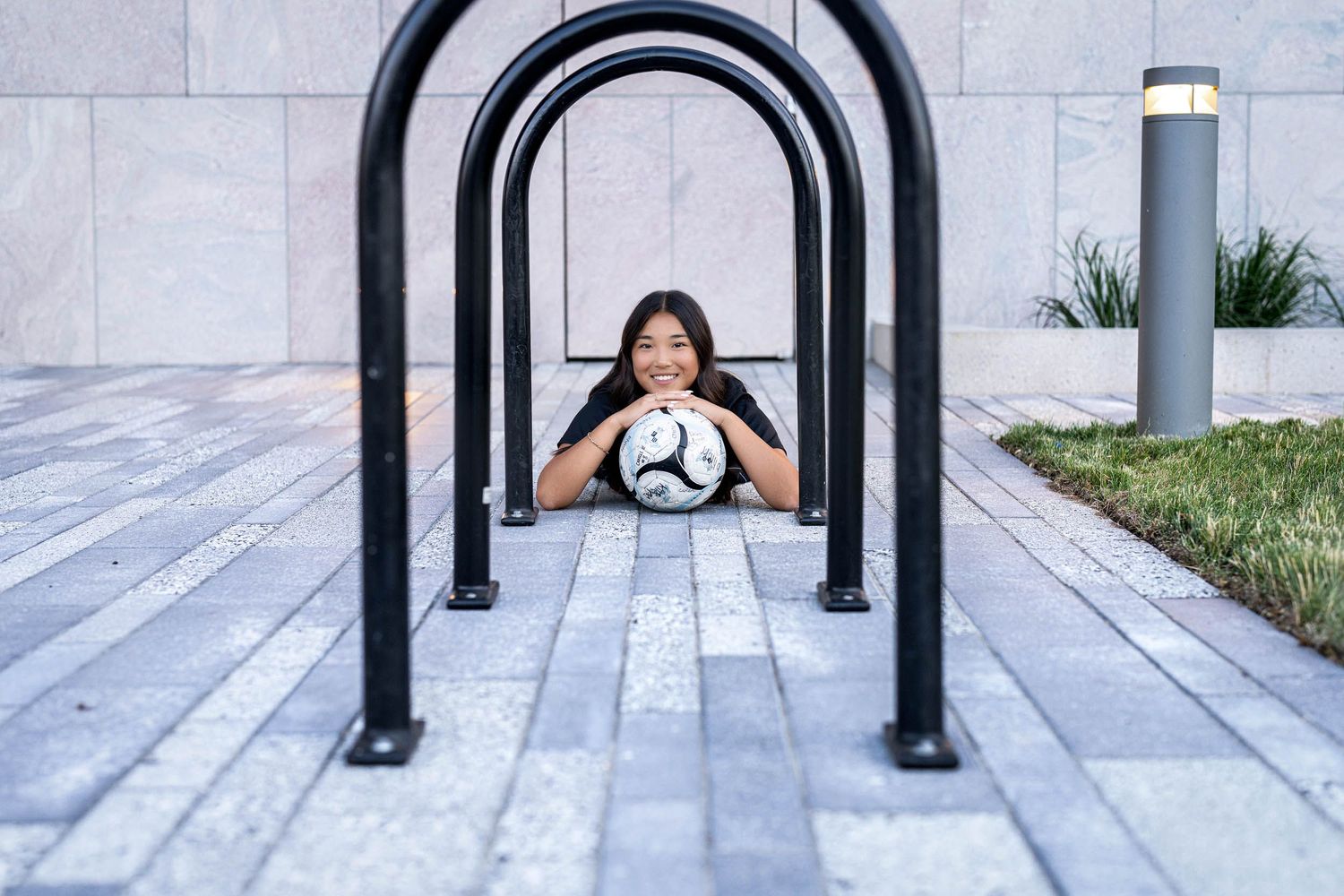 Soccer player practicing ball control through black metal arches.