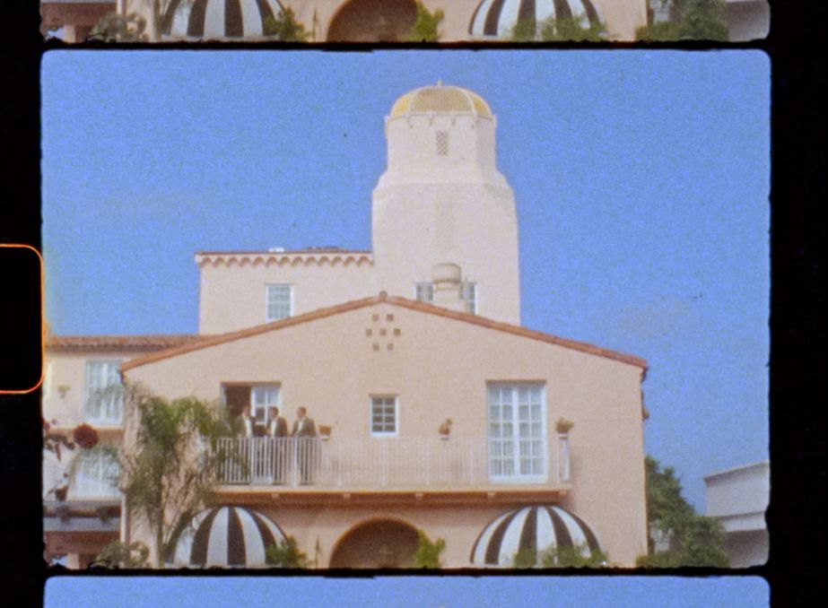 Spanish-style stucco buildings with white walls and terracotta roofs under bright blue sky.