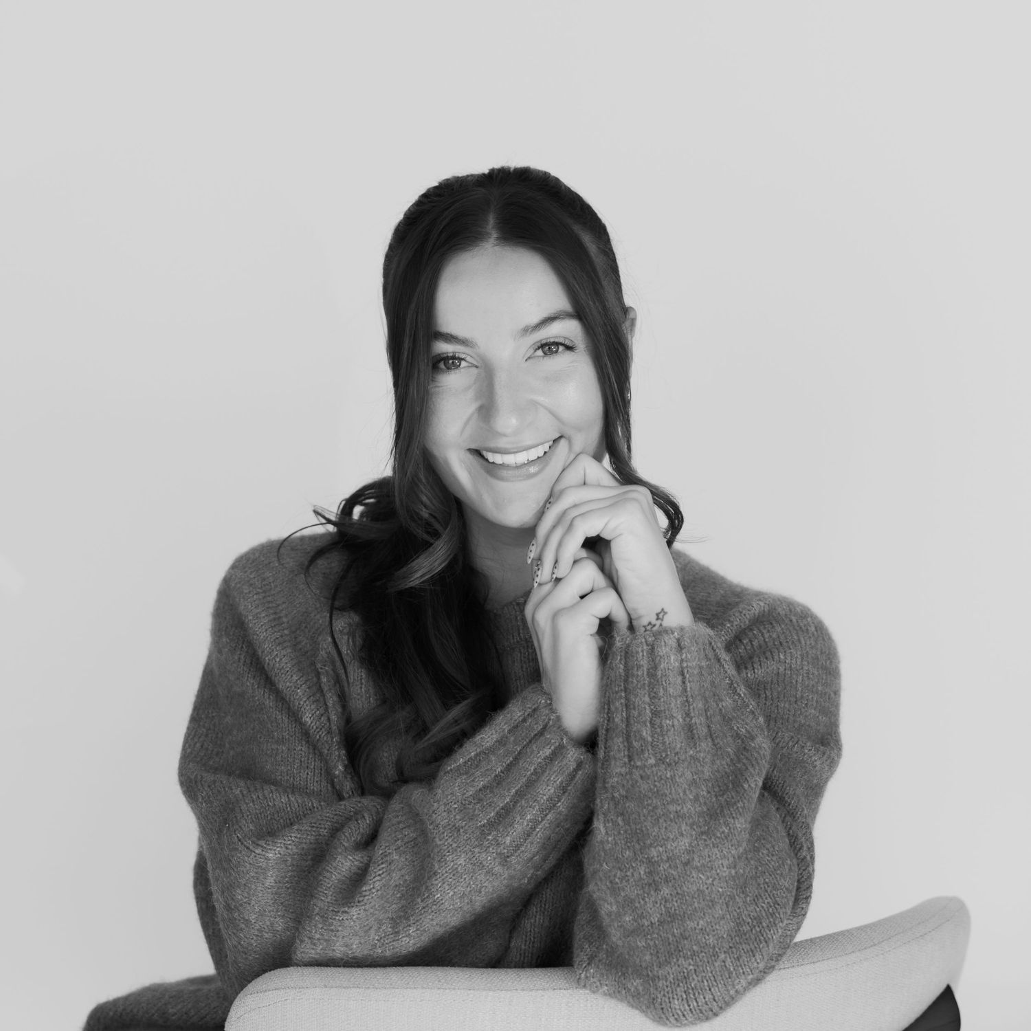 Person in a cozy gray sweater showing various relaxed poses against a light background.