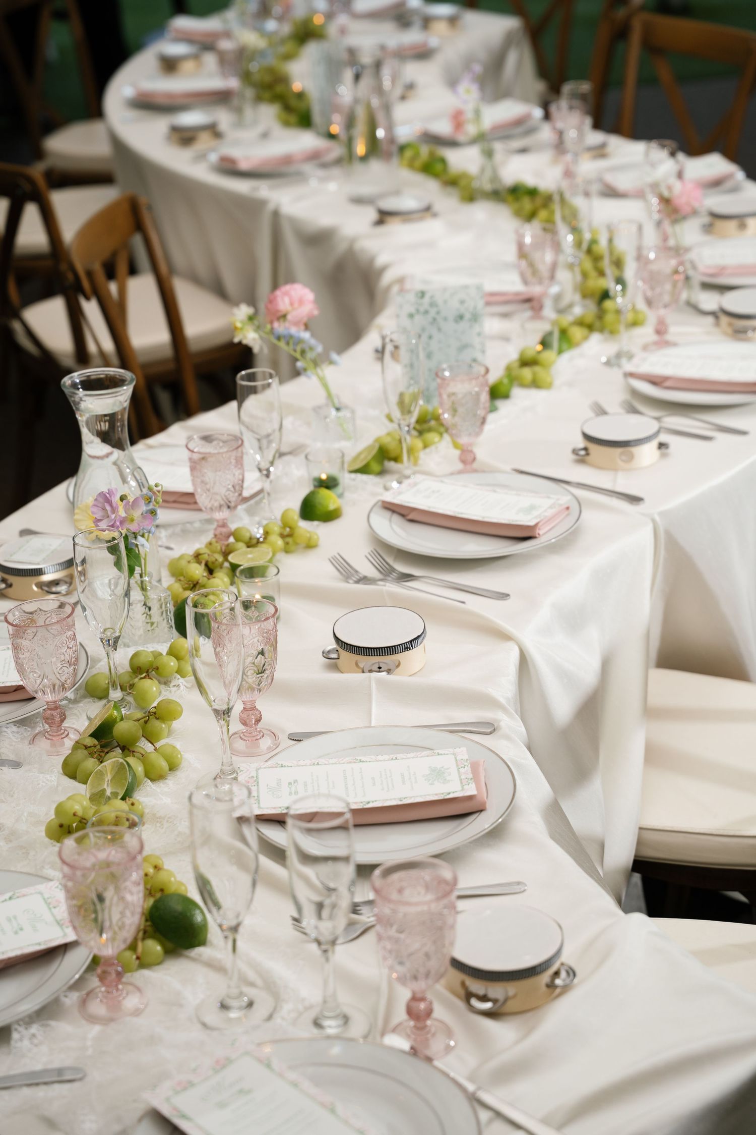 Elegant wedding reception table setting with white linens and delicate floral centerpieces.