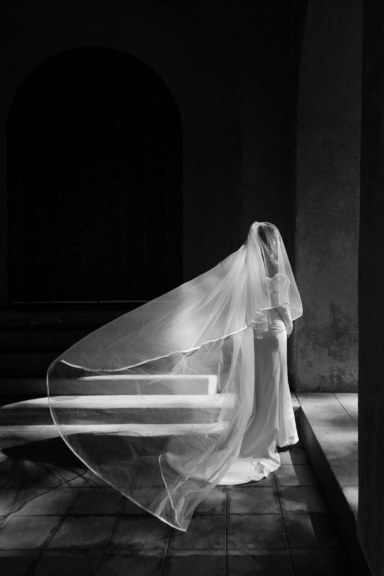 A dramatic black and white photo series showing flowing white fabric creating ethereal shapes in a dark space.