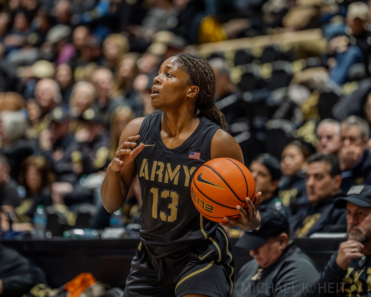 Army basketball player prepares to shoot while Navy defenders attempt to block.