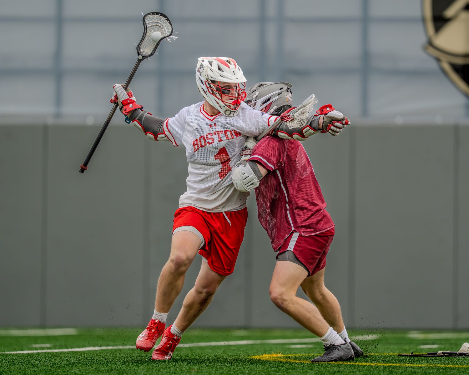Lacrosse players from Boston University and Colgate battle for possession during a game.