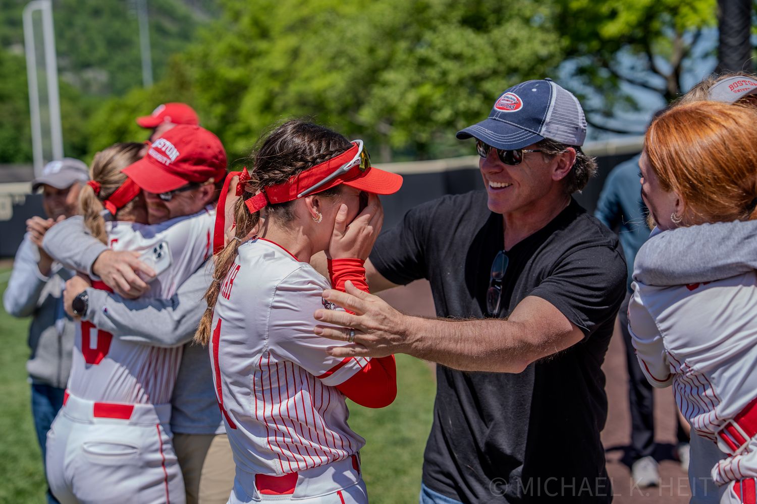 Baseball coaching staff and players celebrate together during game.