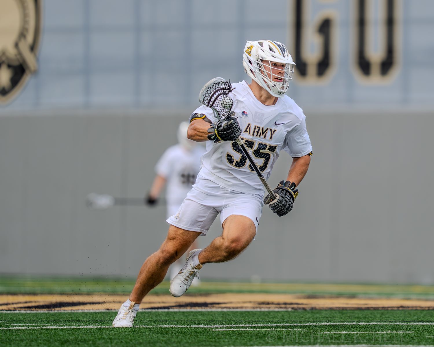 Lacrosse players from Army team maneuver on the field during competitive play.