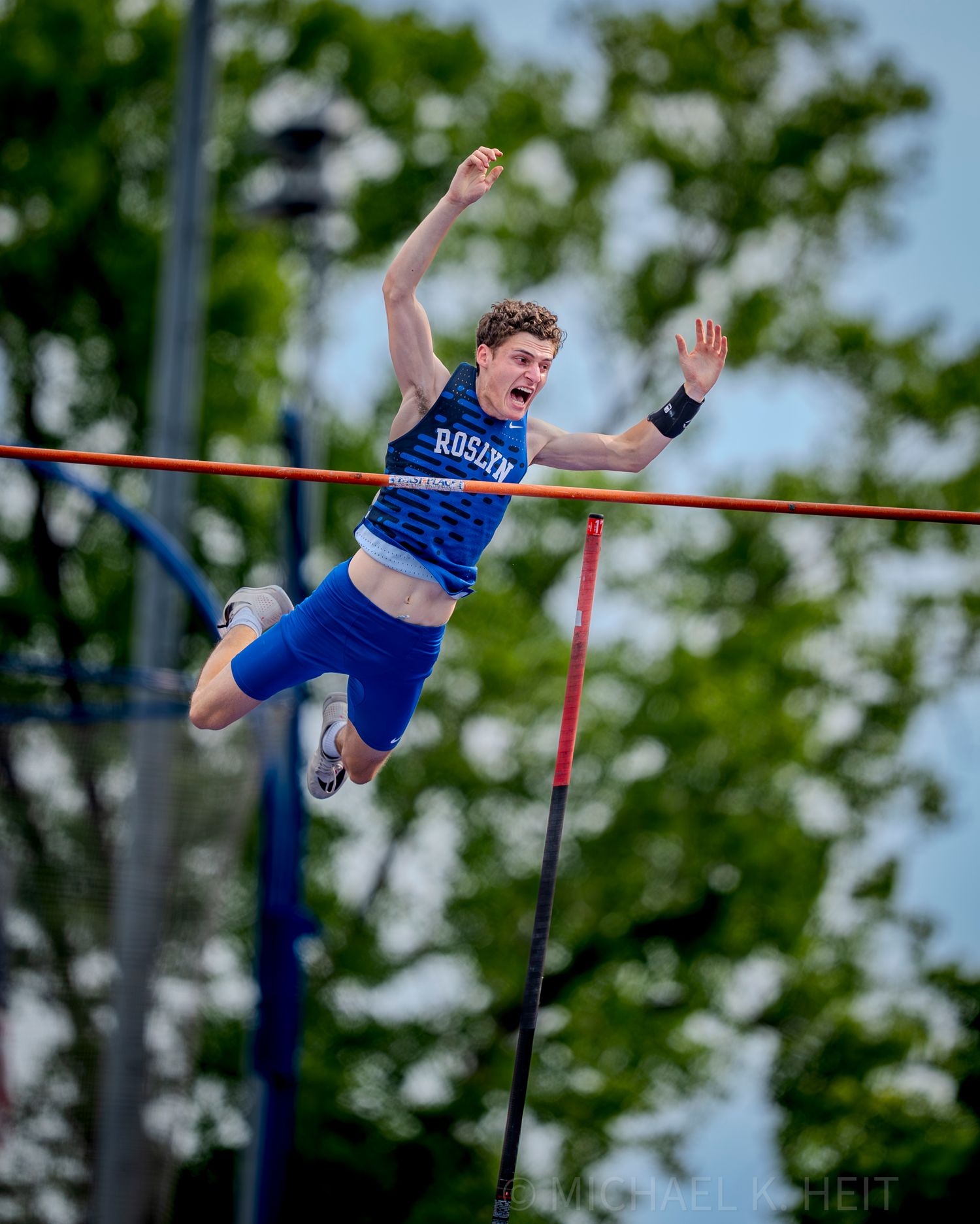High jump athlete clearing the bar during an outdoor track meet.