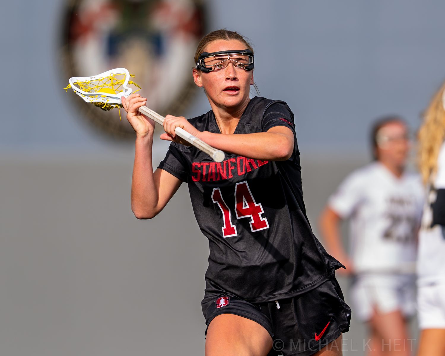 Stanford and Army women's lacrosse players compete for possession during gameplay.