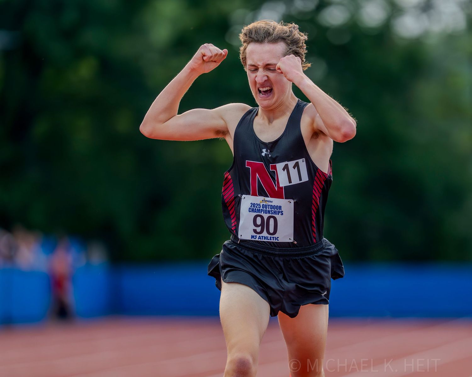 Track athletes celebrate and show emotion after finishing their race.