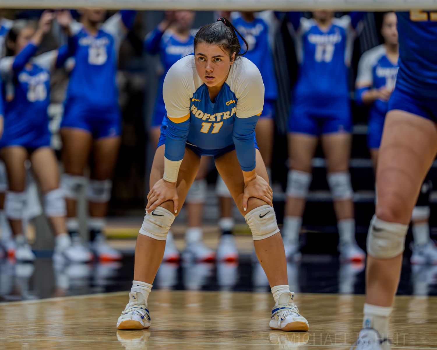 Close-up of volleyball players' feet and legs in defensive stance position.
