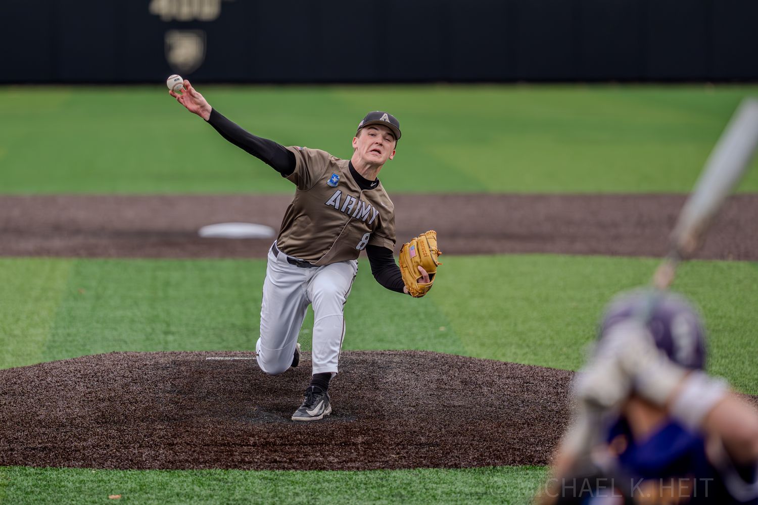 Baseball pitcher winds up to throw from mound during competitive game.