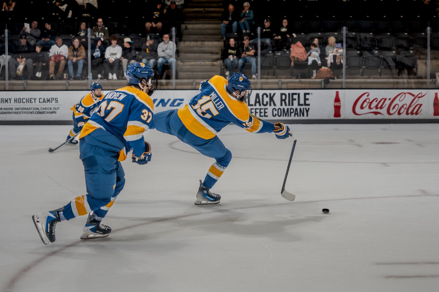 Players from opposing teams battle for puck control during fast-paced hockey match.