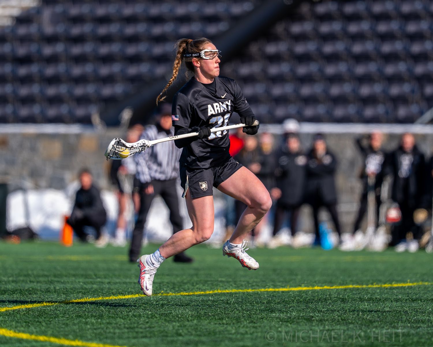 Lacrosse player diving horizontally through the air to make a dramatic play on the field.