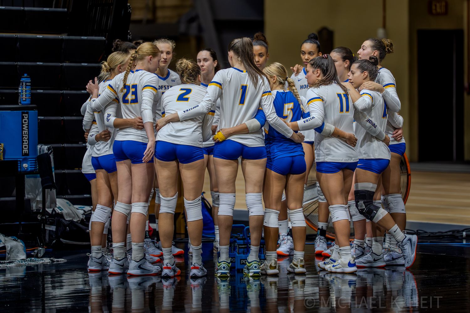 Team huddles together on the volleyball court before starting the game.