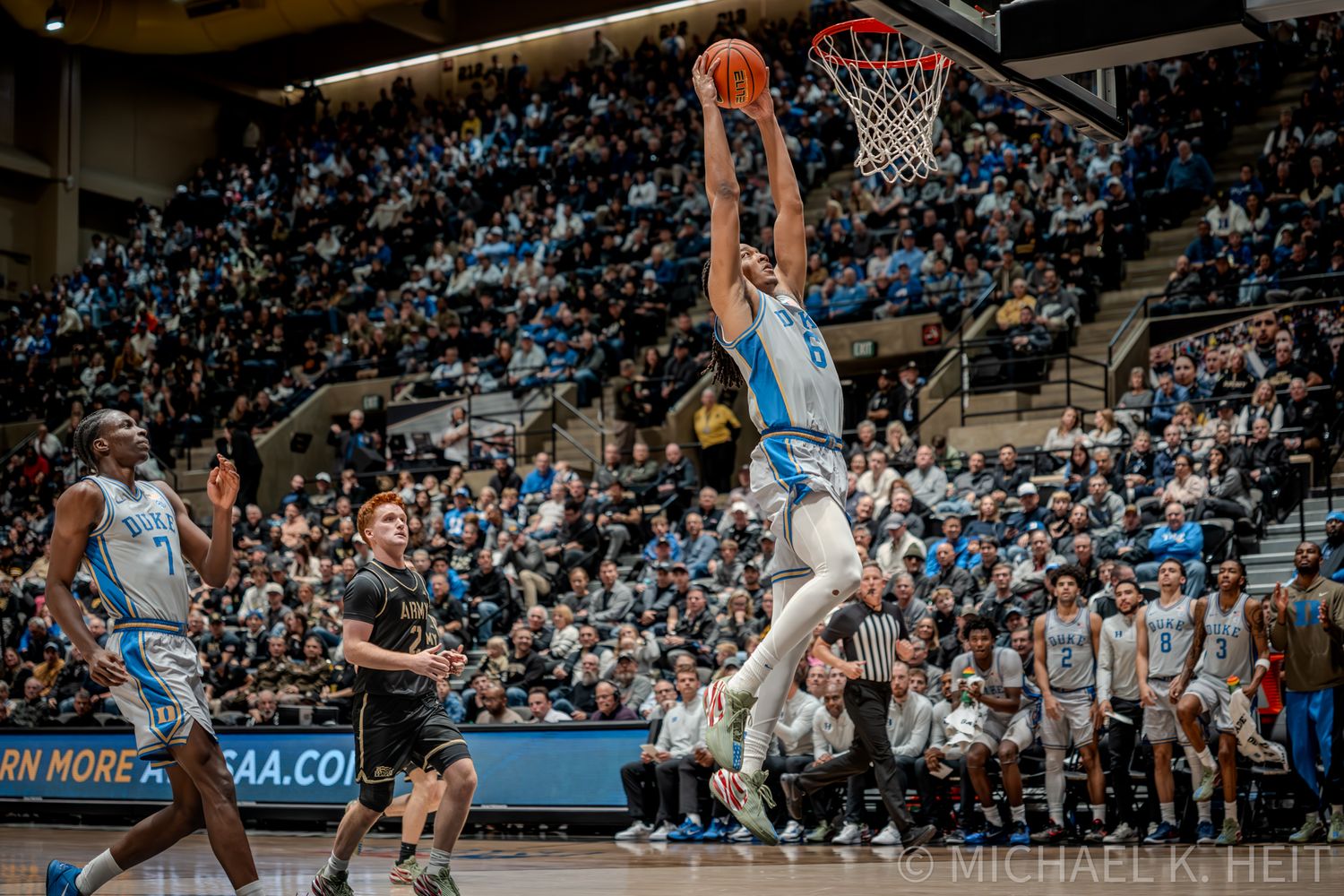 A basketball player soars high for a slam dunk during an intense game.