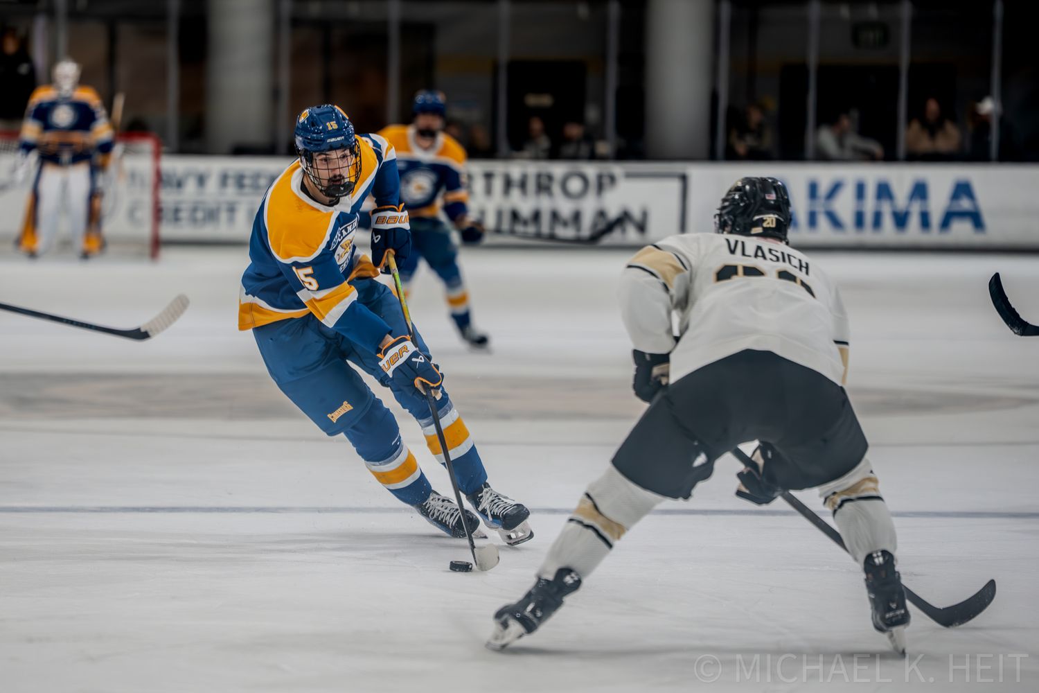 Hockey player in blue and yellow jersey performs dynamic skating maneuver during intense game action.