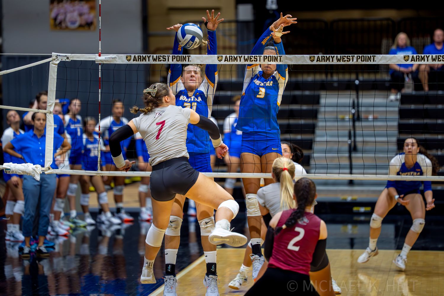 Volleyball players in action during competitive indoor match.