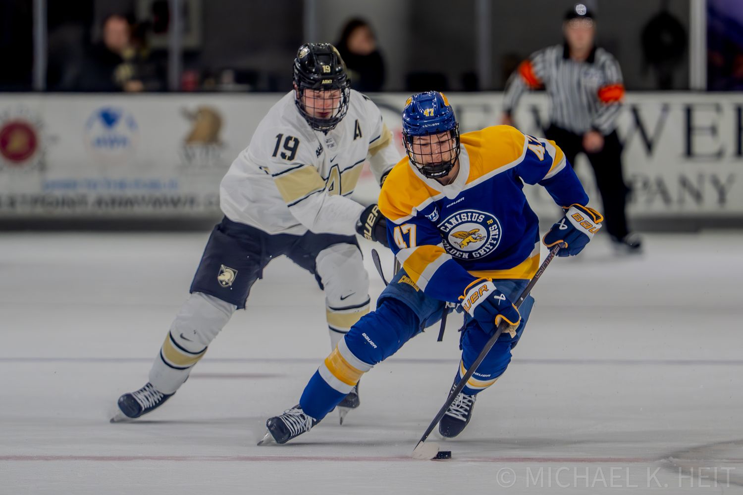 Two opposing hockey players chase after the puck during a fast-paced game.