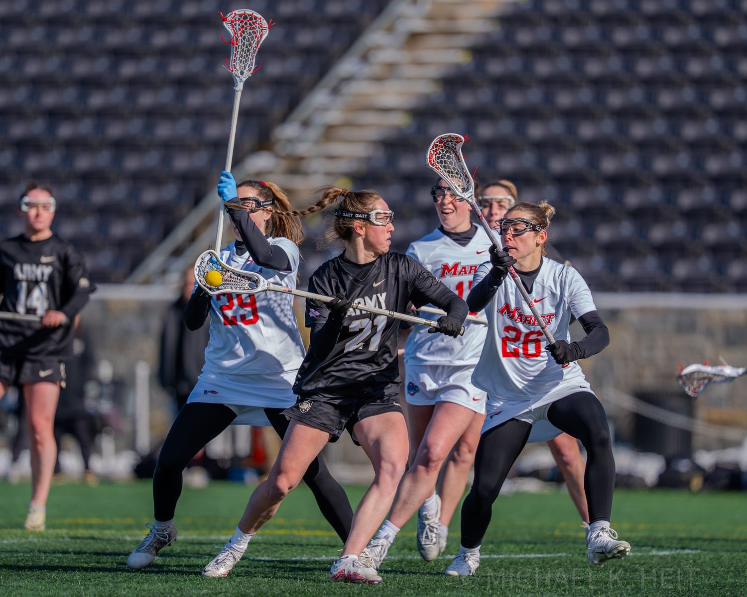 Multiple players compete for a ground ball during an intense lacrosse match.