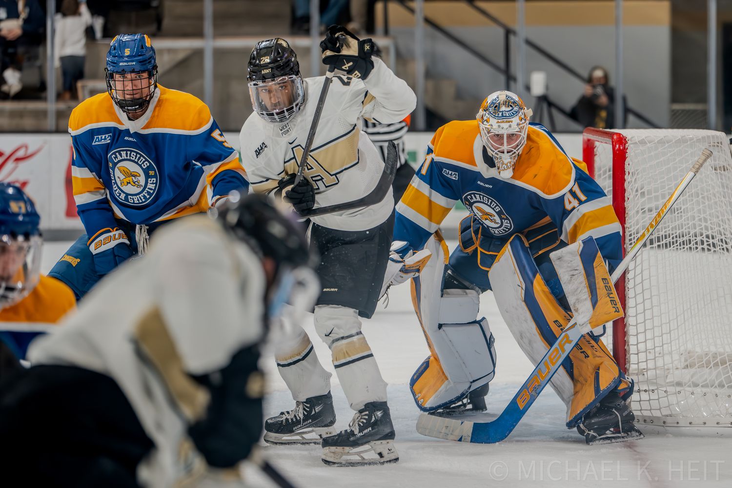 Hockey players from opposing teams battle near the goal during intense match.