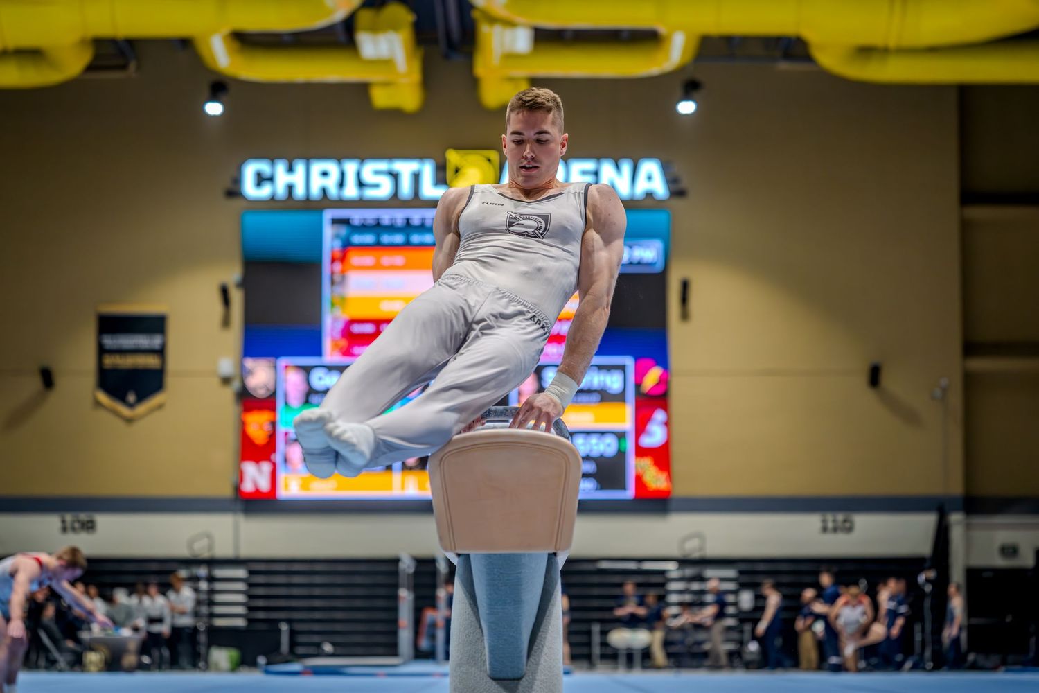 Male gymnast performing on pommel horse at Christl Arena during a collegiate gymnastics competition.