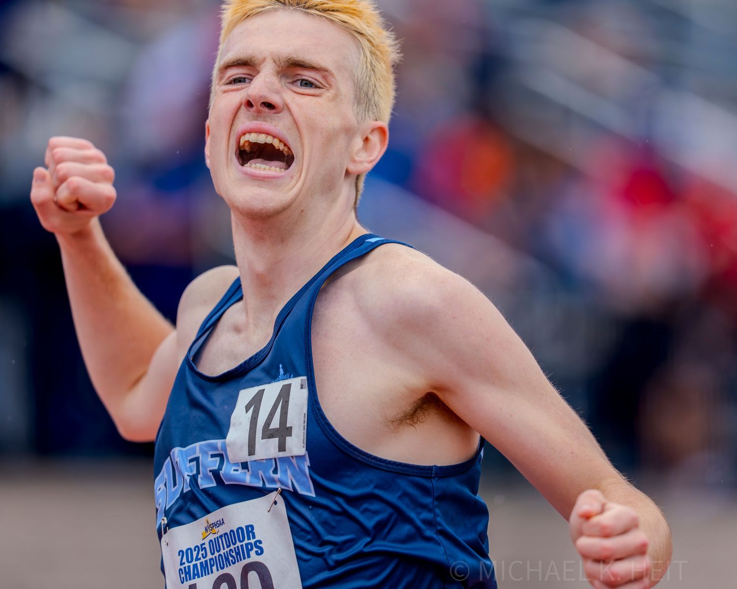 Track athletes celebrate with arms raised in victory after a competitive race.
