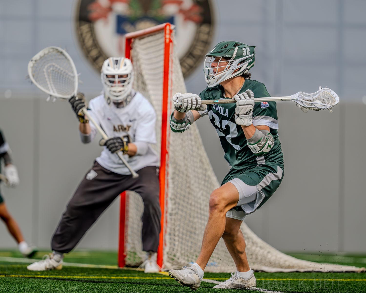 Two lacrosse players battling near the goal during an intense game moment.