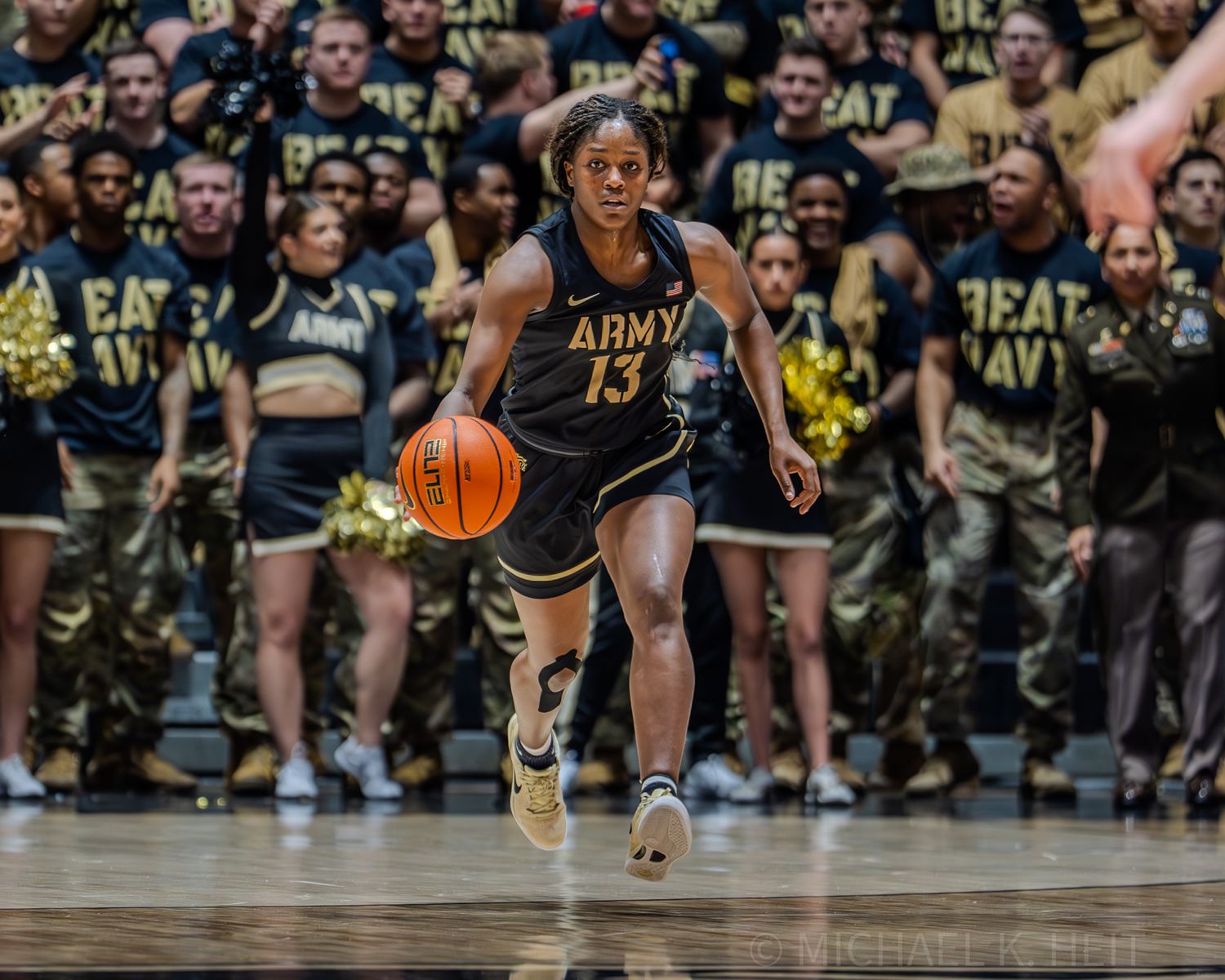 Players from Army and Navy scramble for a loose basketball on the court.