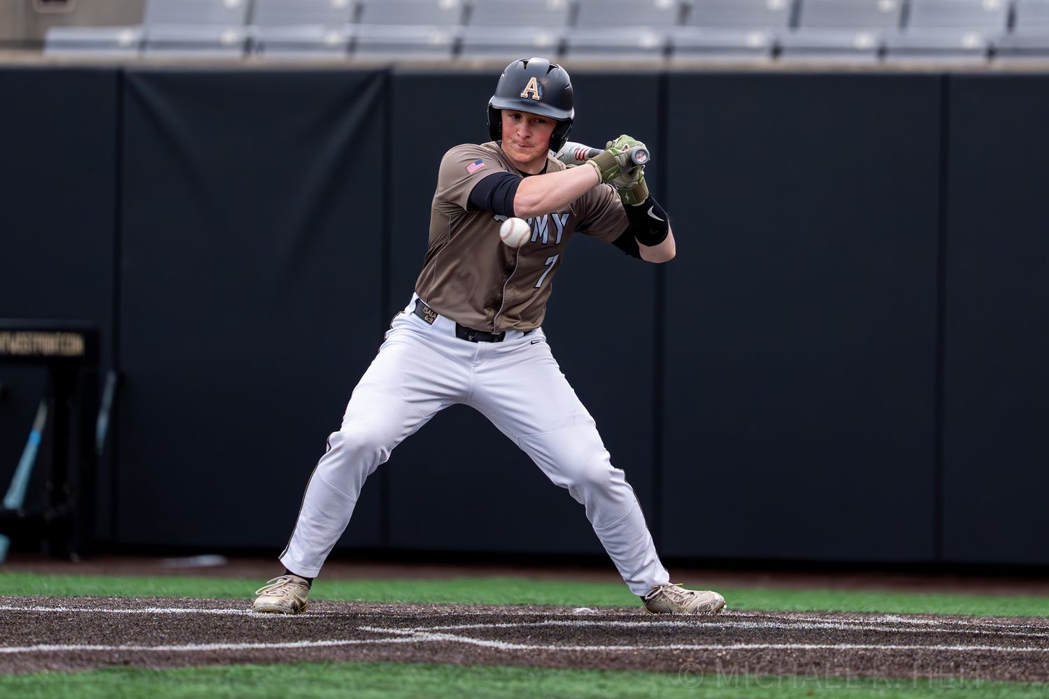 Baseball player prepares to field ball on infield dirt during game.