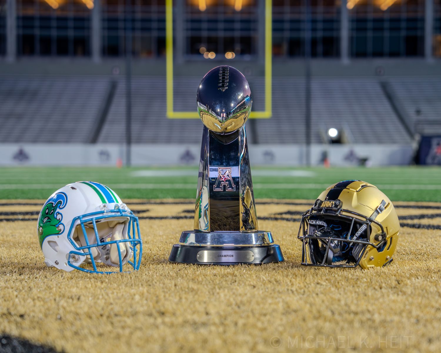Football helmets and equipment line up on the field during a game.