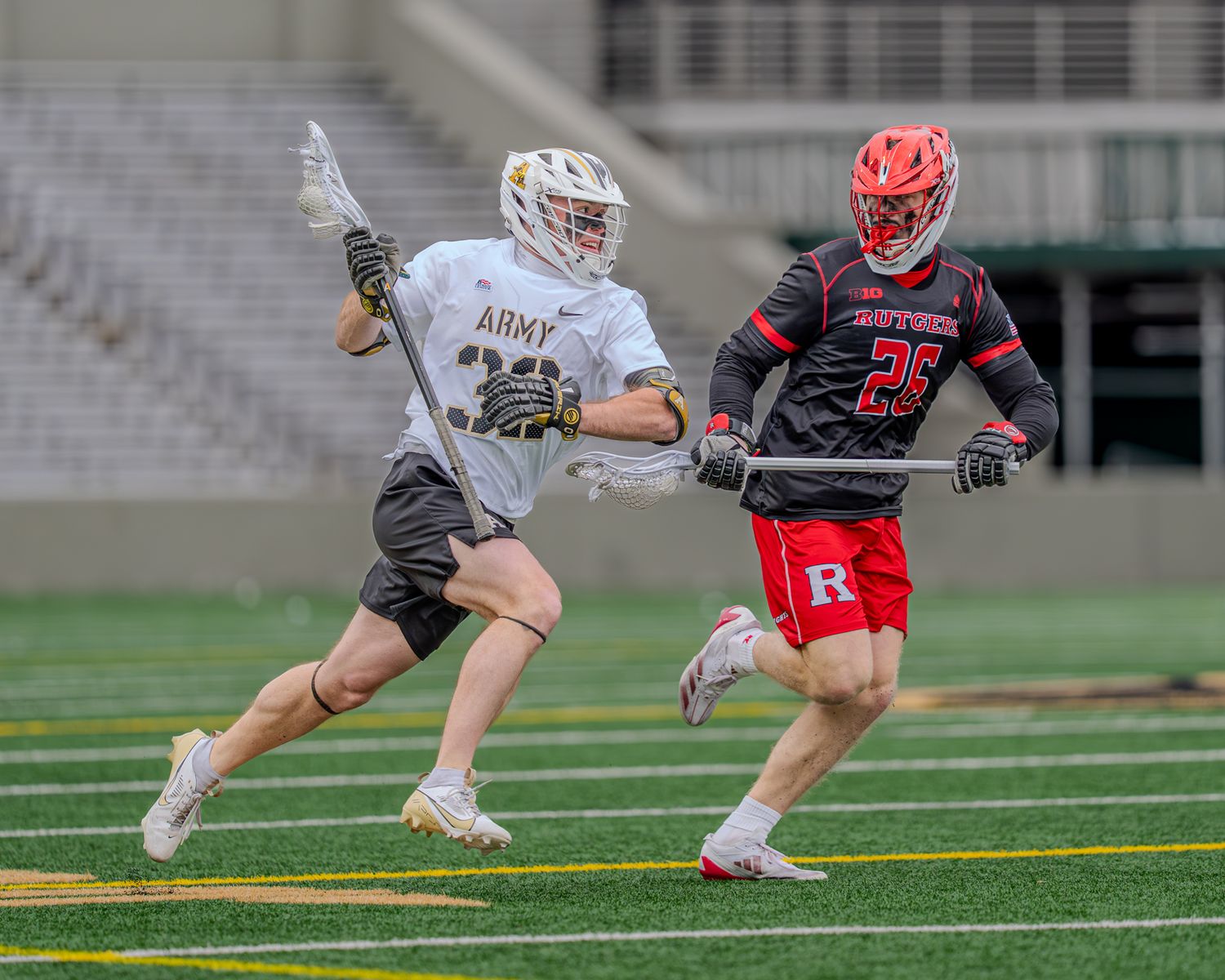 Army and opposing team players engage in competitive lacrosse ground battle.