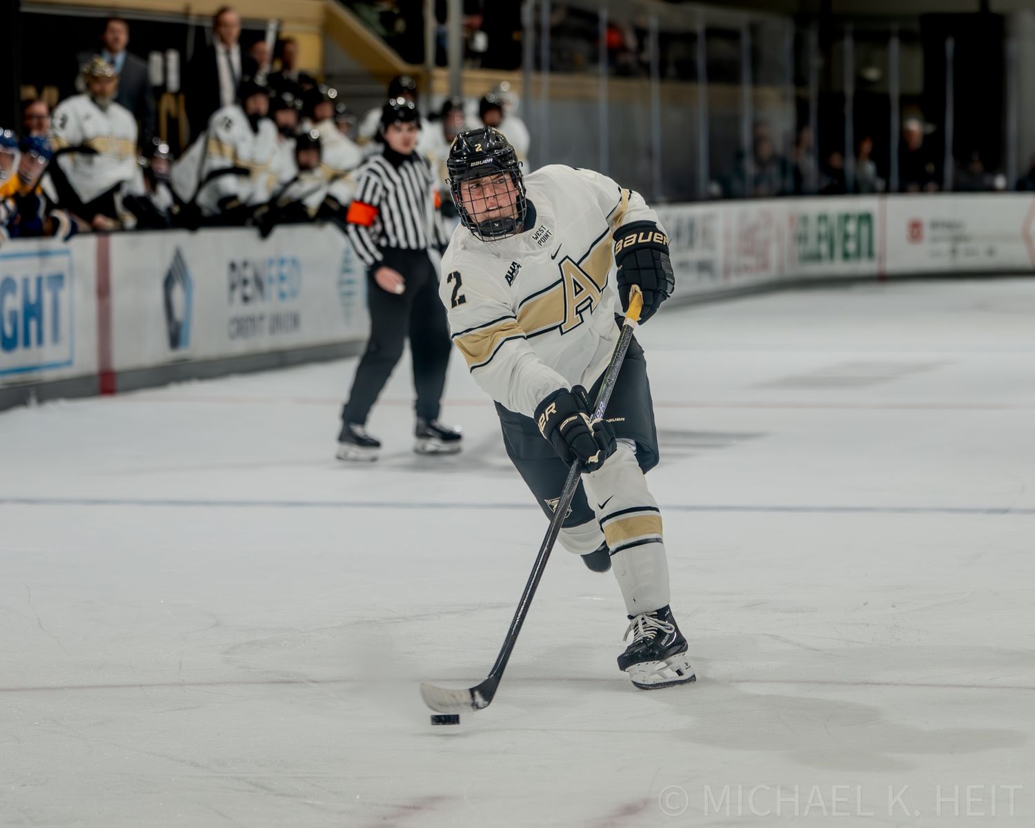 Hockey player skating with the puck during competitive game.
