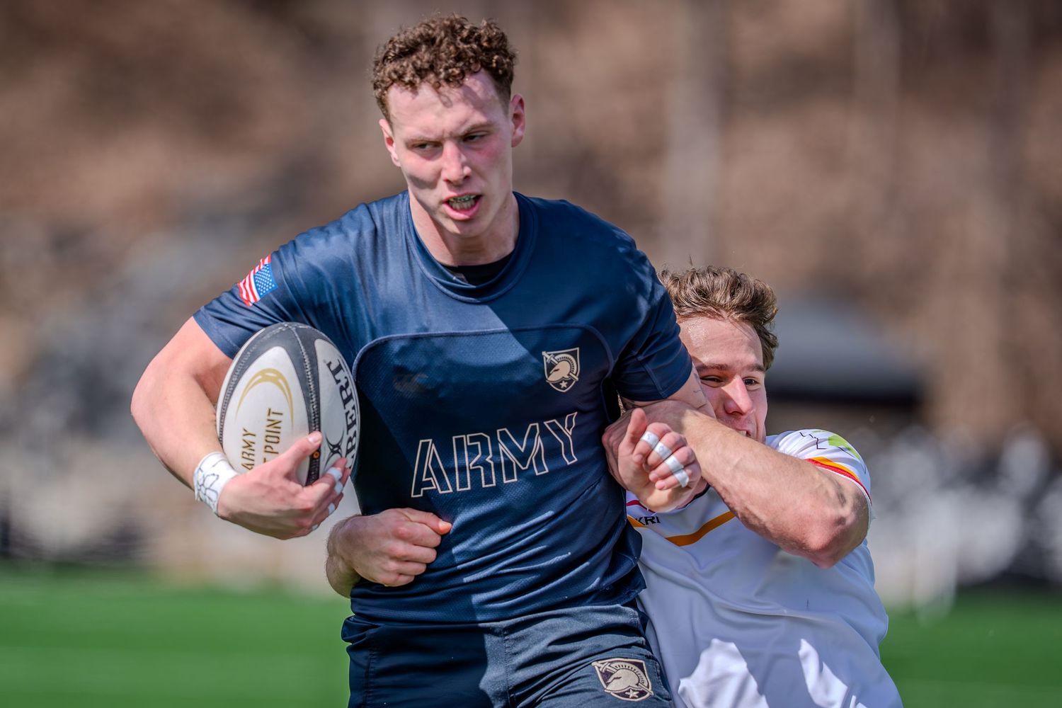 Rugby players compete for possession of the ball during an intense match on the field.