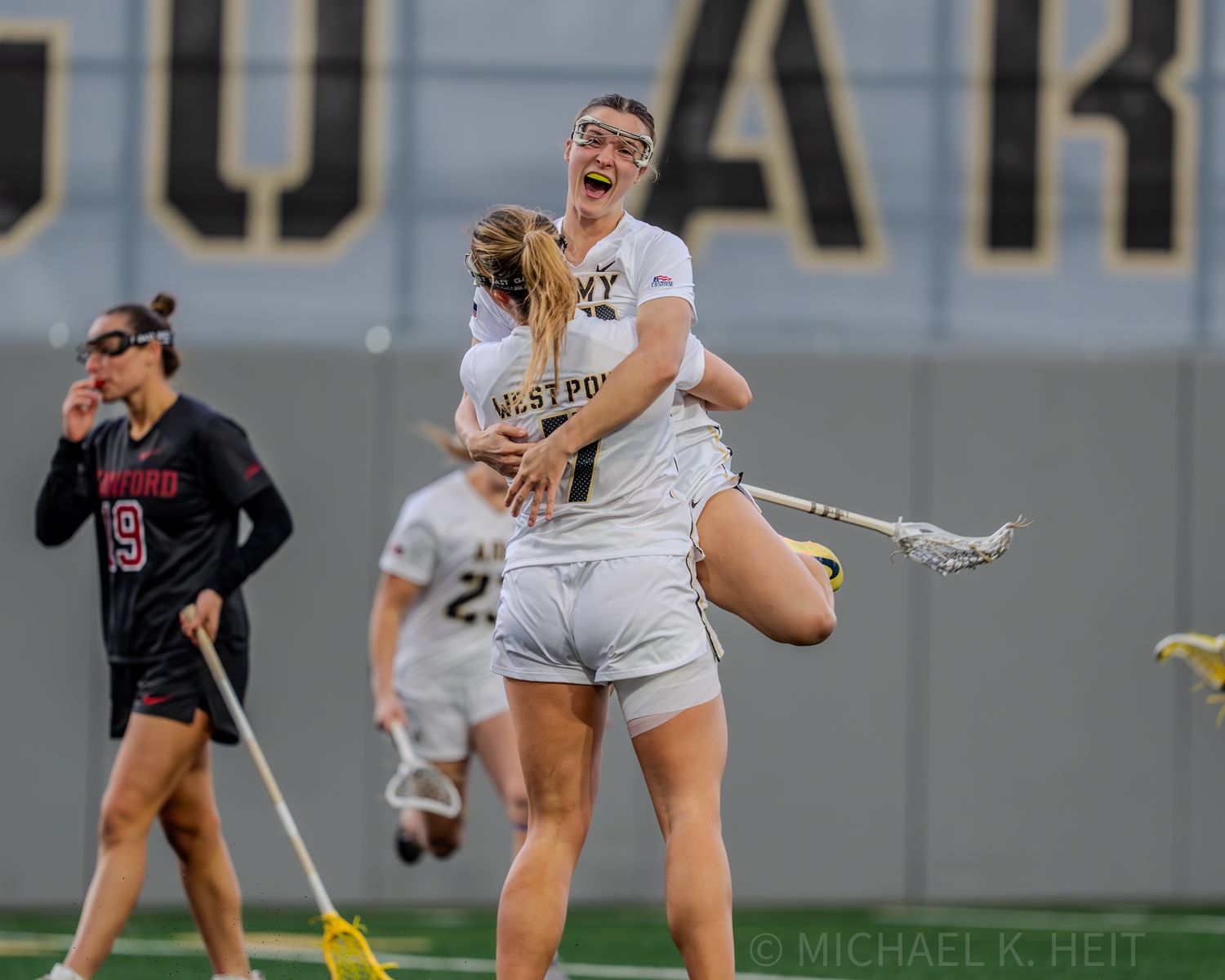 Players scramble for possession during a women's collegiate lacrosse game.