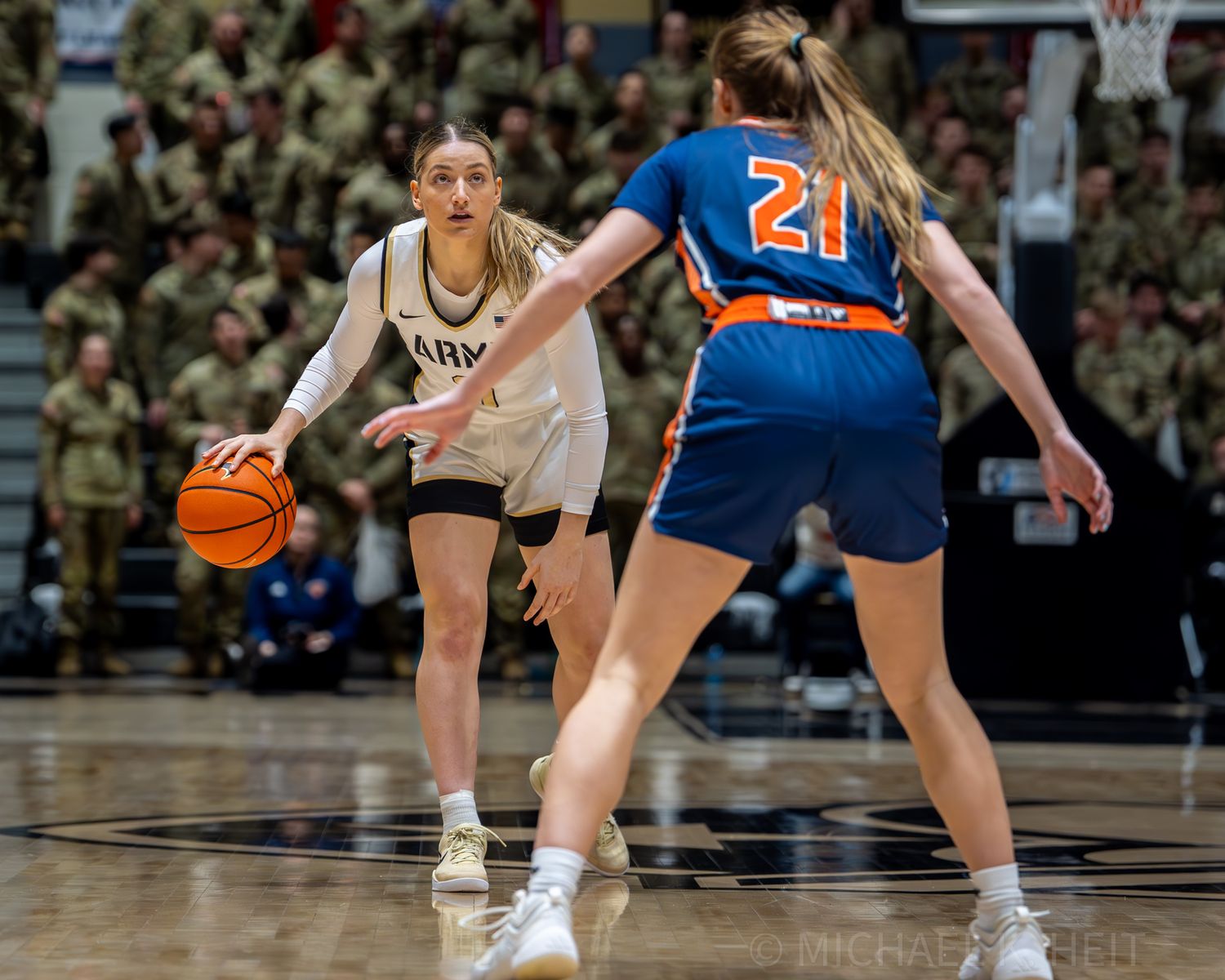 Basketball players display defensive stances during competitive gameplay on the court.