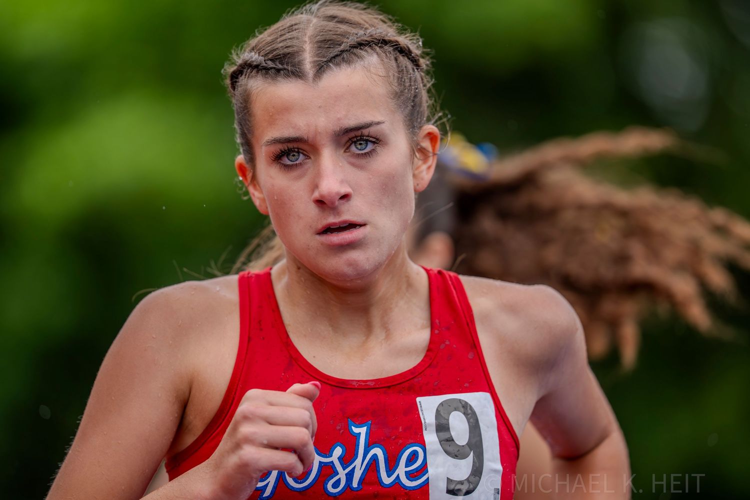 Athletes compete in a track event with focused determination.